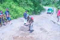 Tampak Babinsa Koramil 1501-04/Sahu Sertu Sem Yesua Boimau saat bersama-sama dengan warga memperbaiki akses jalan raya yang rusak (Foto/Koramil 1501-04/Sahu)