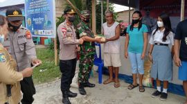 Tampak Babinsa Sertu Luter Mala didampingi Kapolres dan Anggota memberikan sembako kepada warga yang ikut melakukan vaksin dosis I 