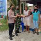 Tampak Babinsa Sertu Luter Mala didampingi Kapolres dan Anggota memberikan sembako kepada warga yang ikut melakukan vaksin dosis I 