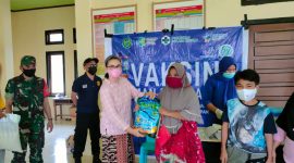 Tampak Babinsa Serma Irwan S saat mendampingi warga usai melakukan vaksinasi dan penyerahan sembako terhadap warga