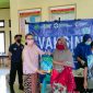 Tampak Babinsa Serma Irwan S saat mendampingi warga usai melakukan vaksinasi dan penyerahan sembako terhadap warga